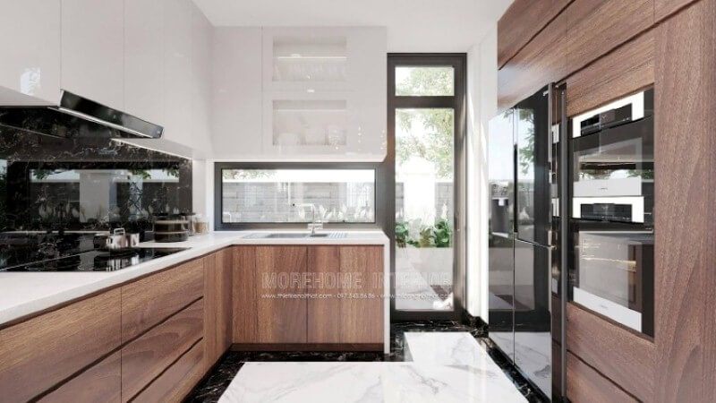 Là một trong những xu hướng thiết kế nội thất nổi bật trong những năm tới, bố trí phòng bếp hiện đại tôn lên vẻ đẹp mộc mạc nhưng không kém phần sang trọng của gỗ điển hình là gỗ óc chó tự nhiên. Loại gỗ rất được ưa chuộng trong các siêu xe bởi vẻ đẹp ấn tượng từ vân, màu gỗ. Như trong ý tưởng thiết kế phòng bếp tại biệt thự Vinhomes Imperia, sự hài hòa tôn lên nét đẹp giữa truyền thống và hiện đại, tủ bếp dưới gỗ óc chó và tủ bếp trên gỗ công nghiệp trắng bóng.